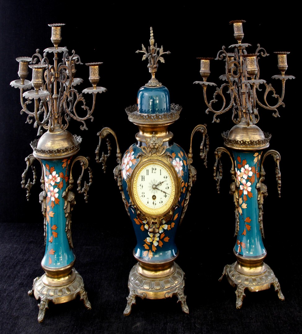 A late 19th/early 20th century three piece French clock garniture, the central classical form