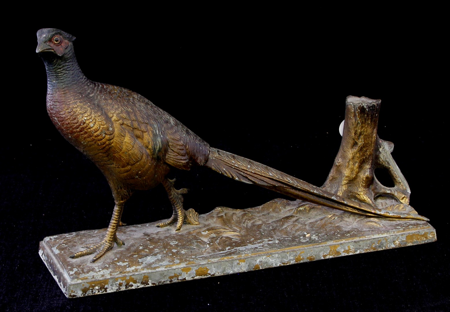 A 19th century patinated spelter figure of a pheasant and tree trunk on naturalistically modelled