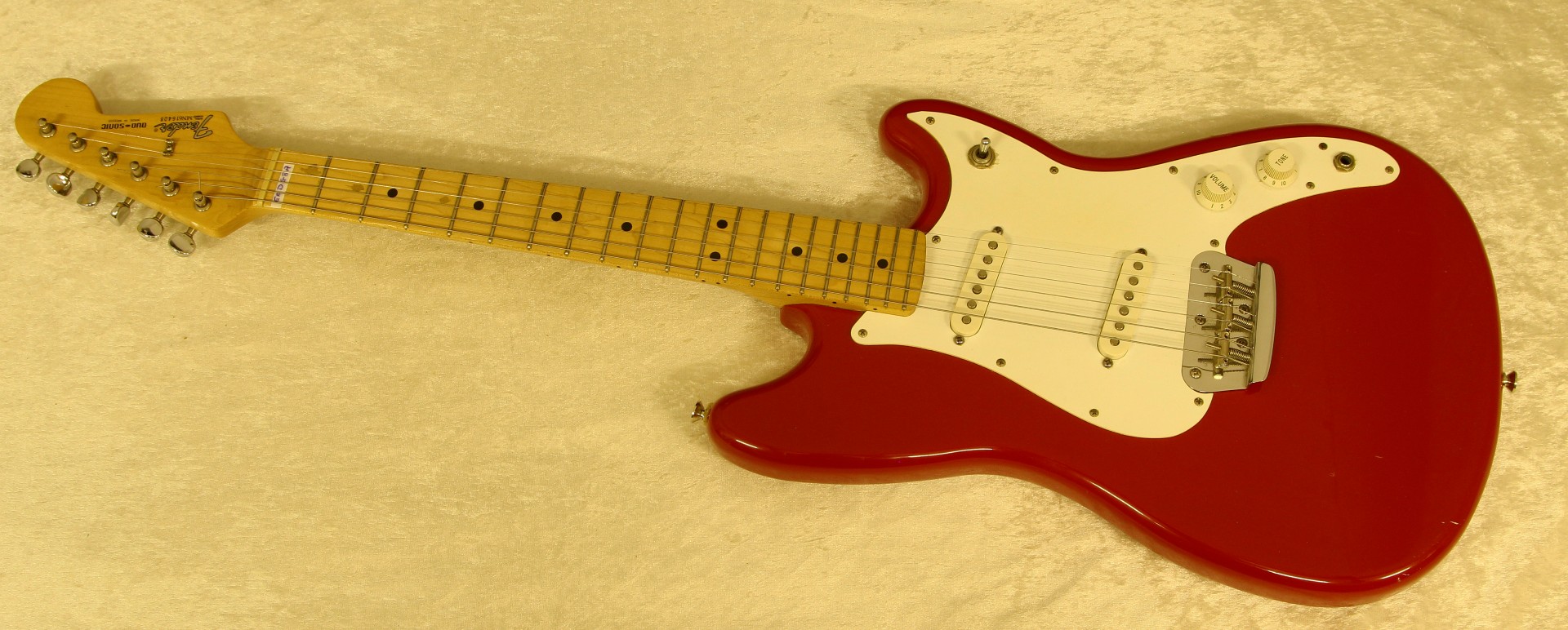 A Fender Duo-Sonic red lacquered six string electric guitar, serial no.MN616408, length 94.5cm