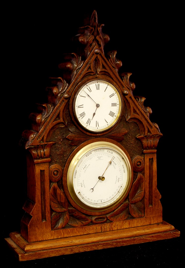 A 19th century Gothic carved oak framed desk top clock barometer/thermometer, the pointed case of