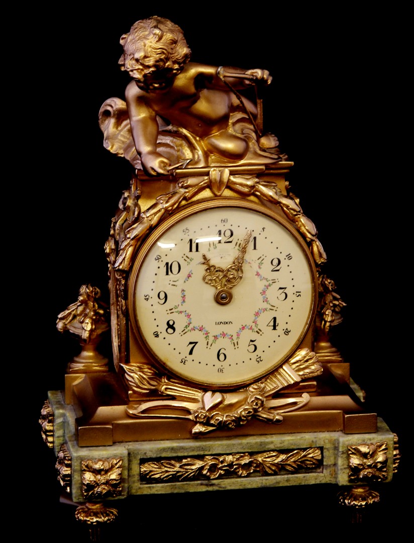 A good quality 20th century reproduction classical Empire style miniature clock, with cherub