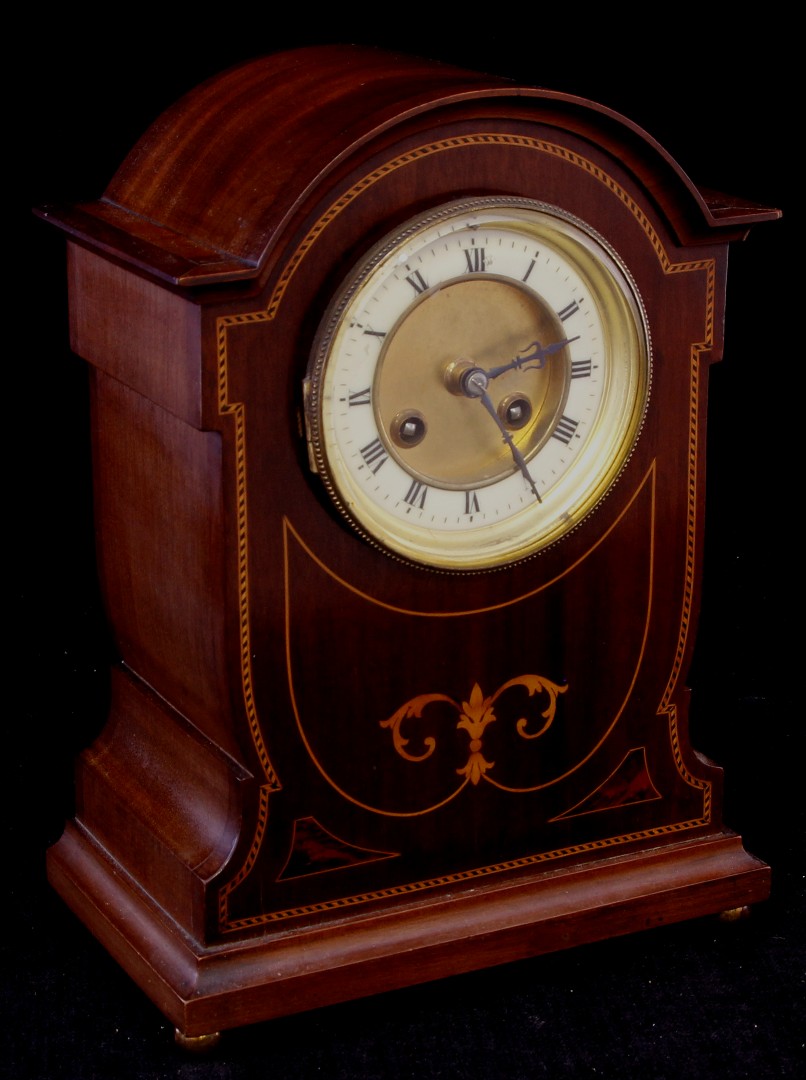An Edwardian inlaid mahogany mantel clock of Art Nouveau form by Japy Frères, with chiming
