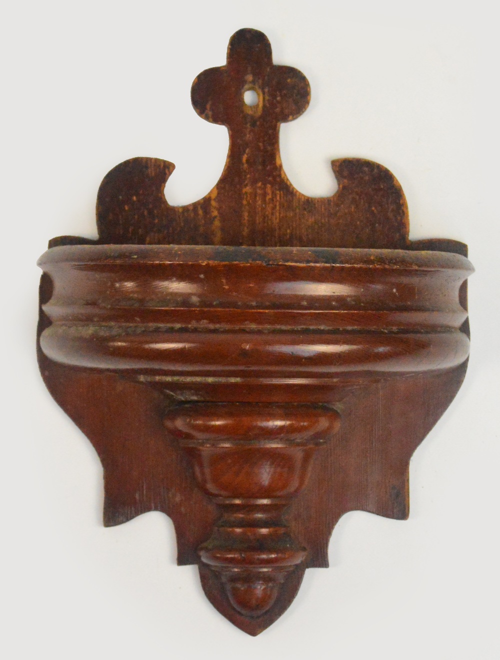 A late 19th century pine wall mounted offertory bowl with pierced back and urn moulded front