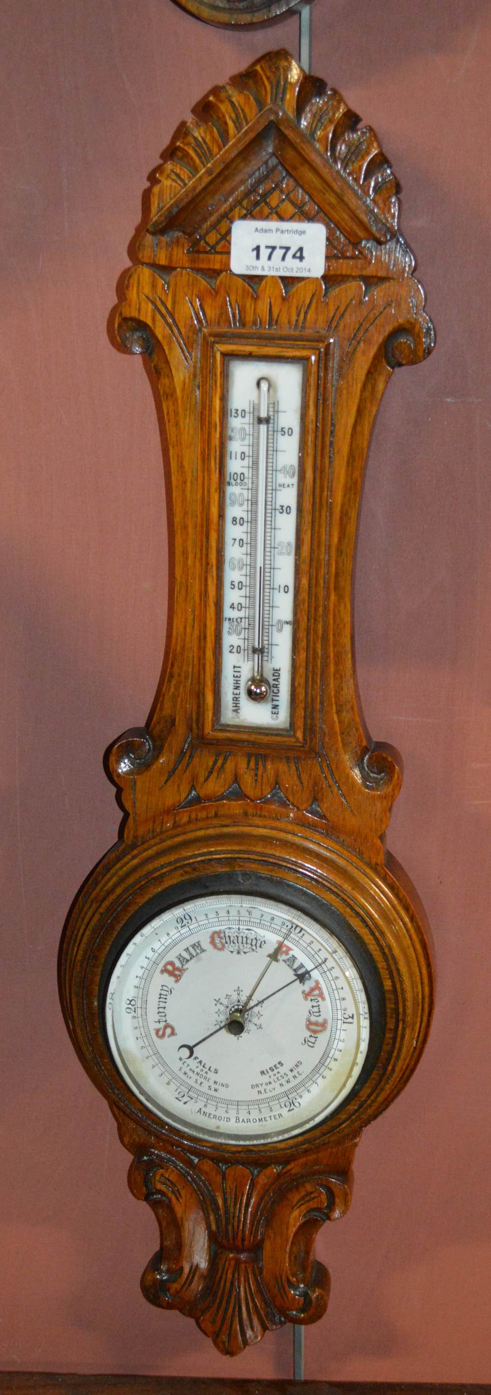 An early 20th century carved oak aneroid barometer.