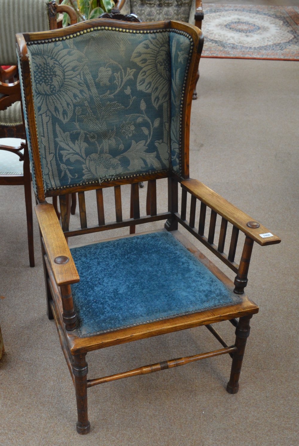 An Arts and Crafts oak framed wing elbow chair.