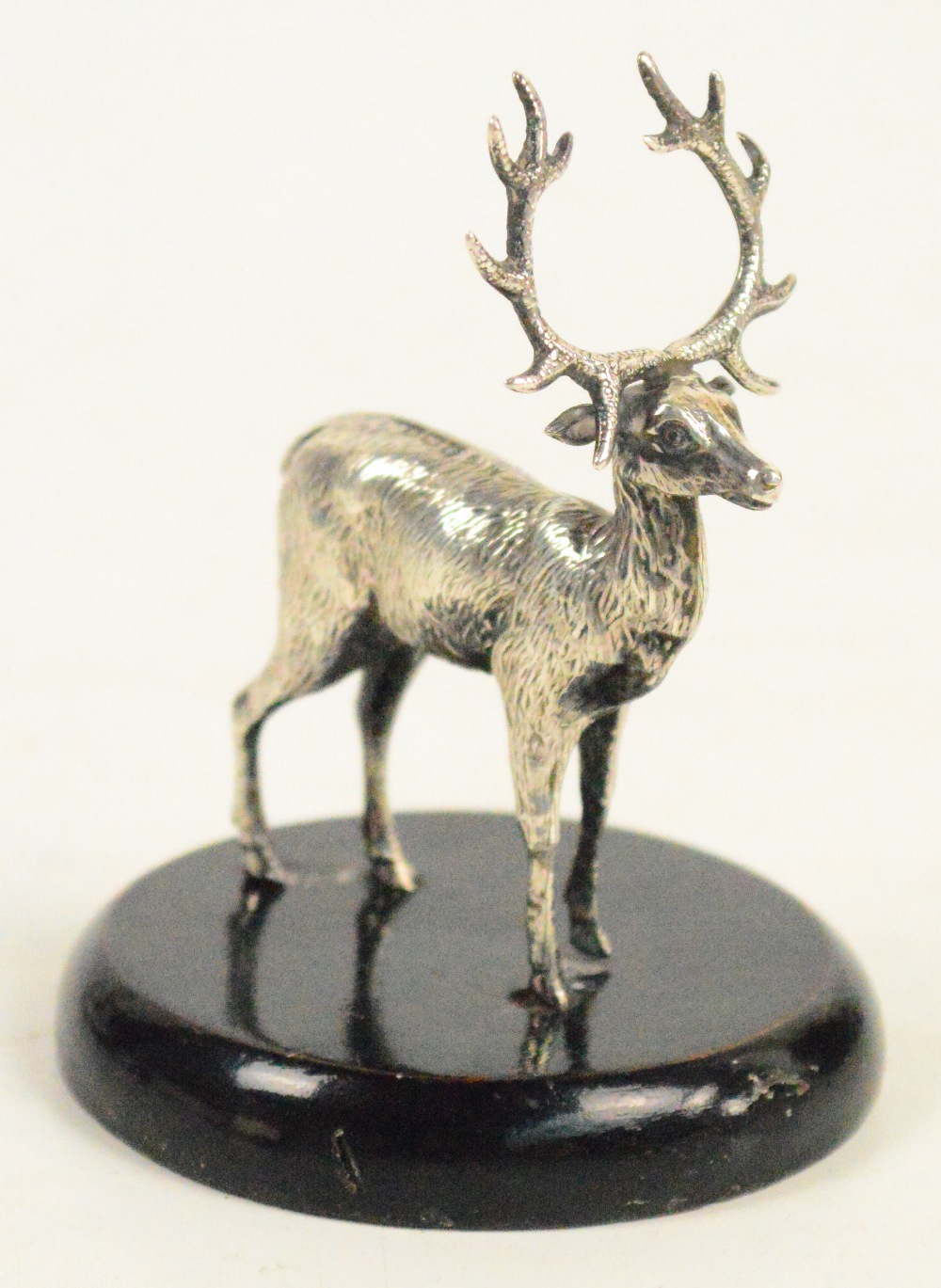 A George V hallmarked silver model of a stag standing four square on ebonised base, Birmingham 1921,