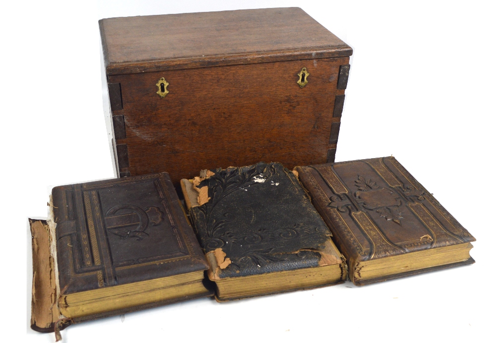 An oak rectangular box containing three Victorian photo albums, one with musical movement.