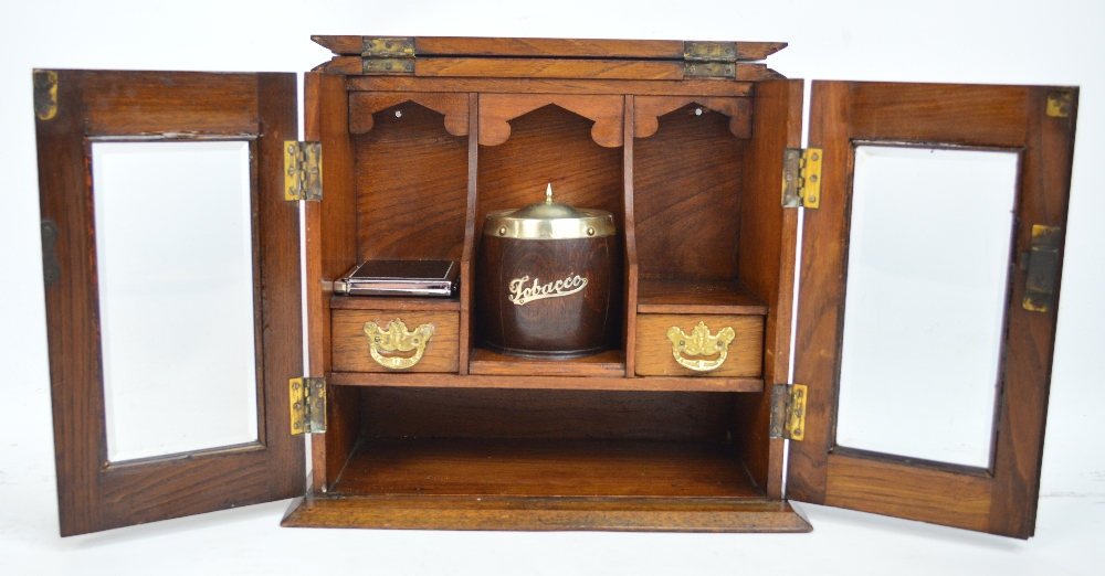 An Edwardian oak smokers cabinet with hinged lid and two doors, width 34.5cm.