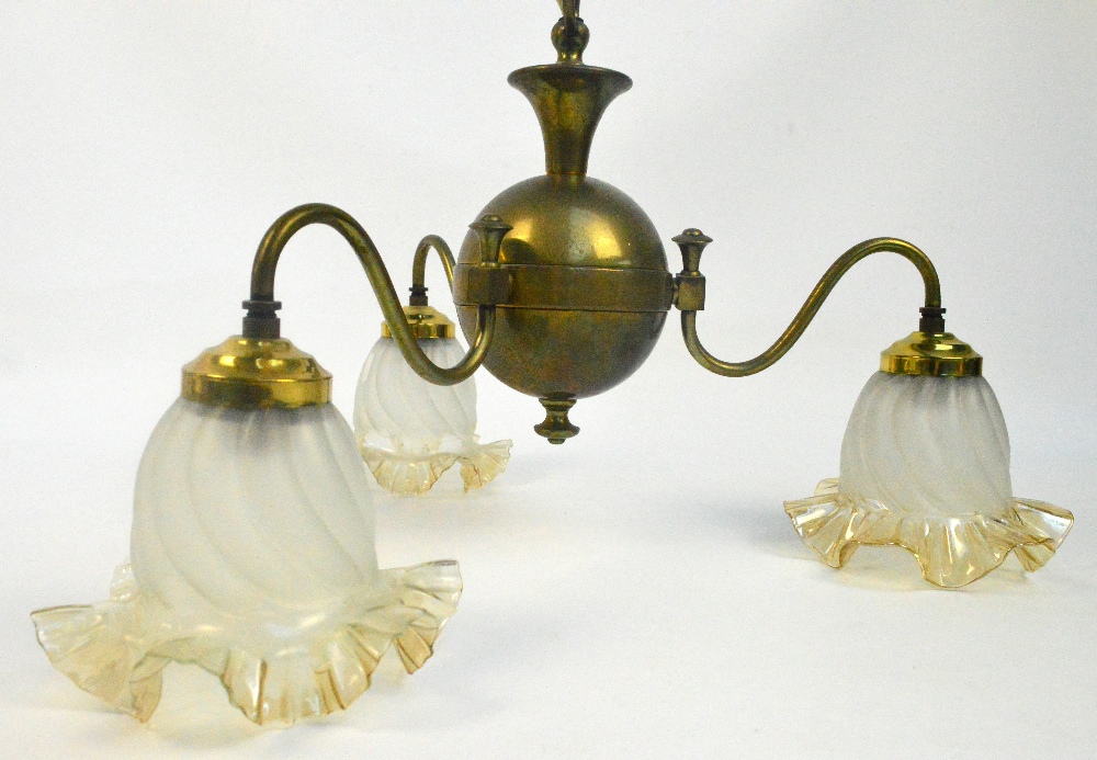 A 1920's/30's brass three branch pendant light fitting with spherical centre and three opaque