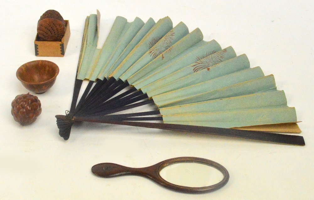A mixed lot of treen to include a carved and pierced coquilla nut, a carved seed pod, a fan and