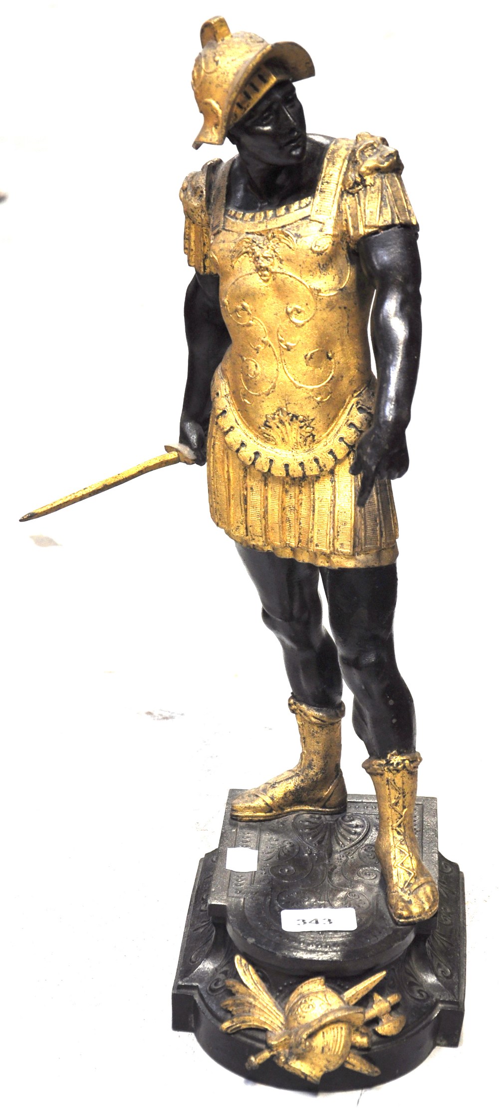 A late 19th century gilt painted spelter figure of a warrior raised on a shaped stepped