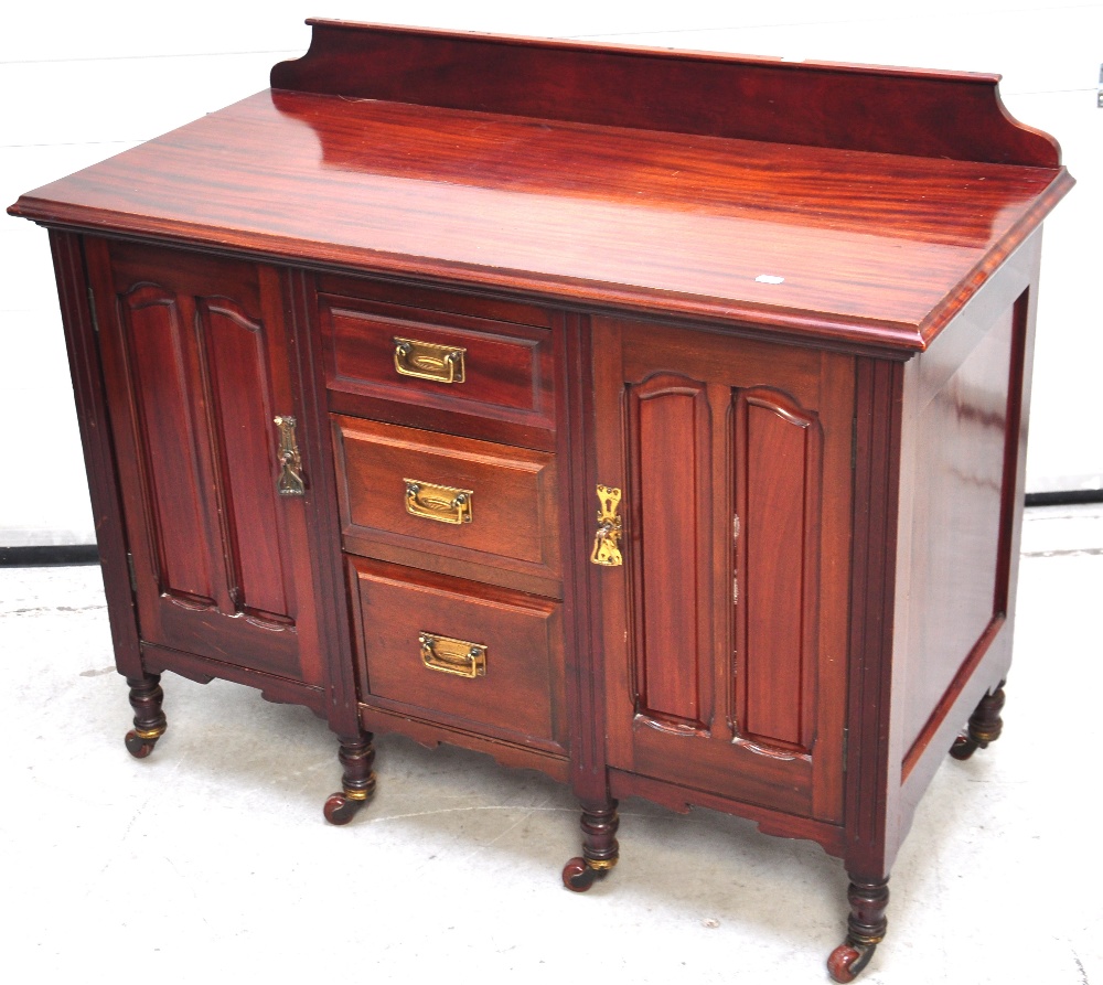 A reproduction mahogany small sideboard, two side doors and three central drawers on castors,