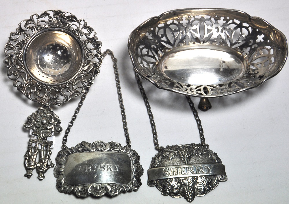 A hallmarked silver filigree footed bon bon dish, two silver decanter labels, sherry and whiskey and