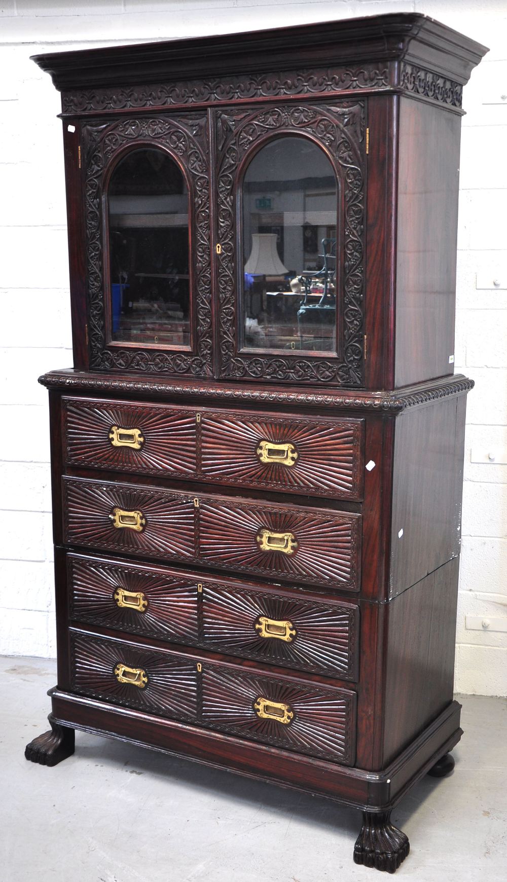 An Indian rosewood secretaire bookcase on chest, the upper section with two glazed doors enclosing a