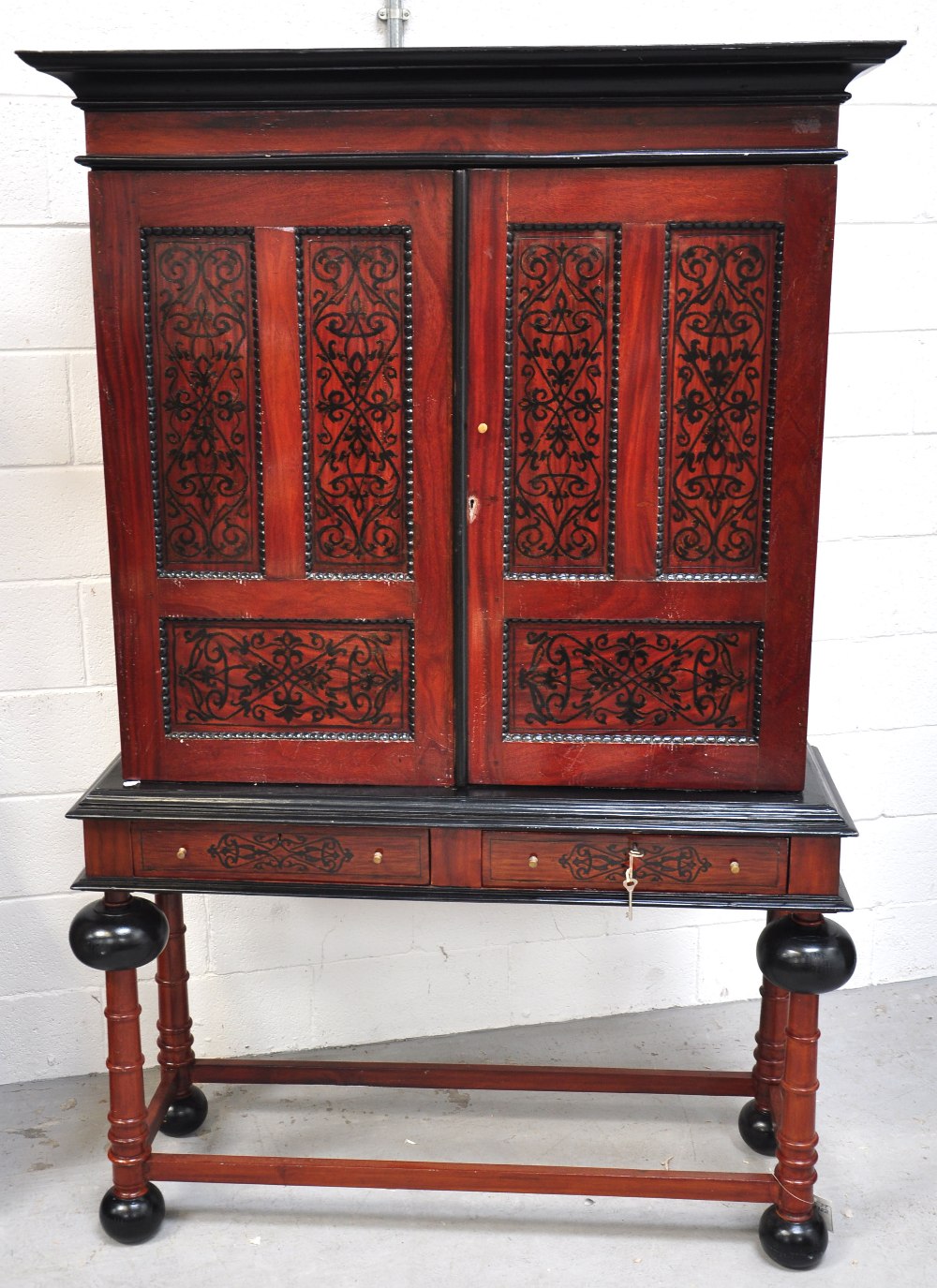 An Indian teak and inlaid bookcase on stand, the upper section with twin panelled inlaid doors