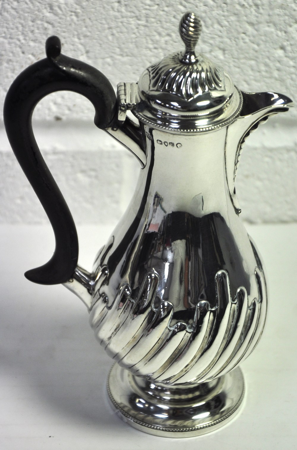 A Victorian hallmarked silver hot water jug with ebonised handle and finial, London 1880, approx