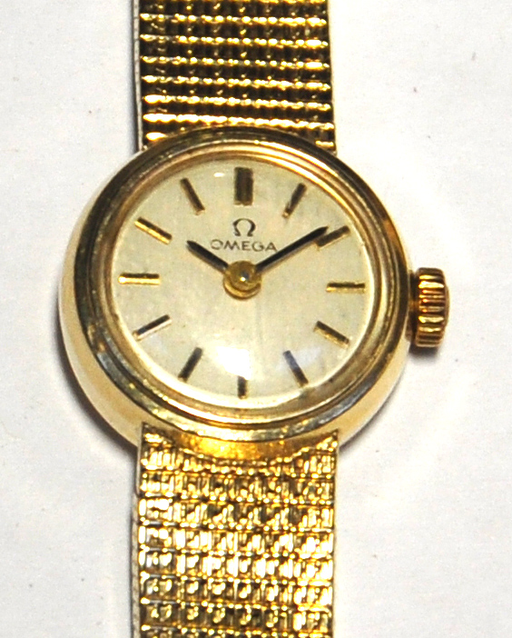 A vintage ladies 9ct gold Omega wristwatch, the circular dial set with gold batons, seventeen