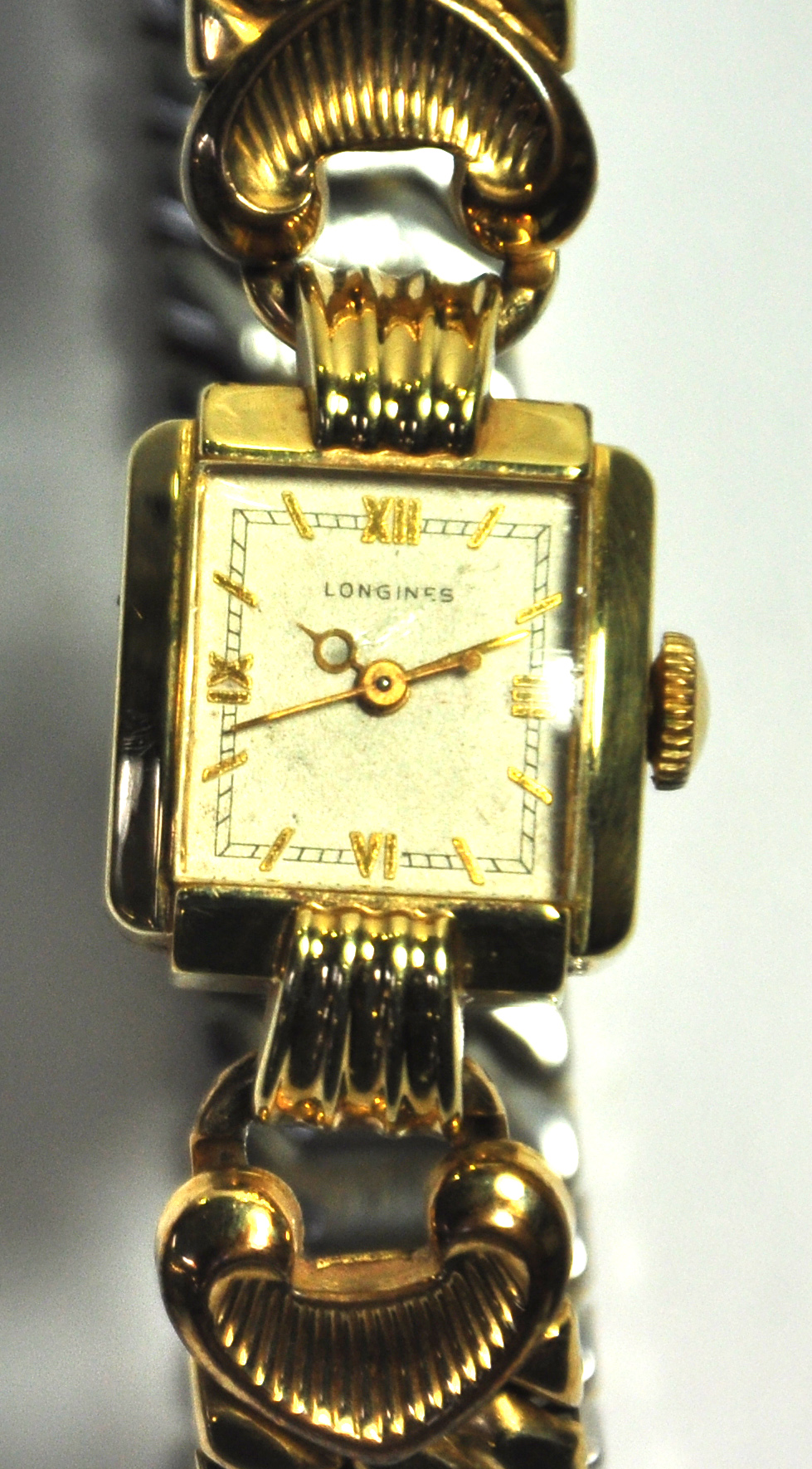 A ladies Longines wristwatch with expandable yellow metal bracelet.