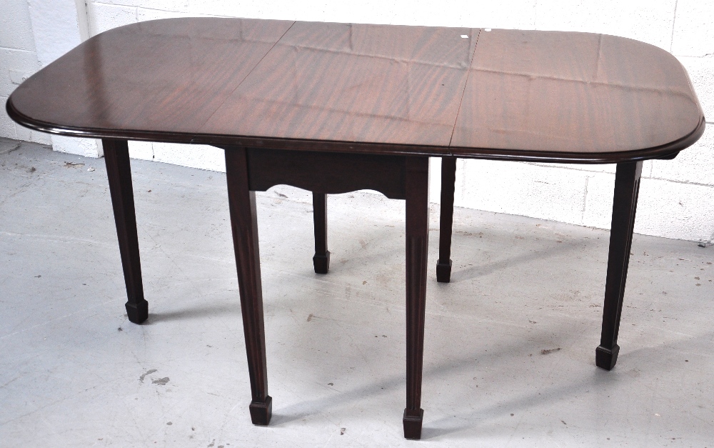 A drop leaf table on tapering fluted legs, length 150cm.