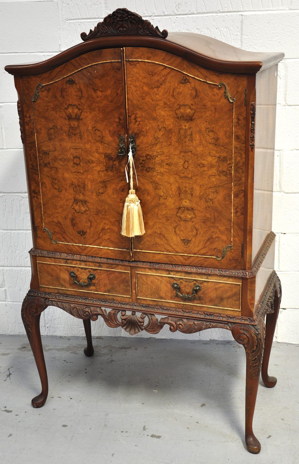 A 20th century reproduction walnut cocktail cabinet raised on cabriole legs, height 162cm.