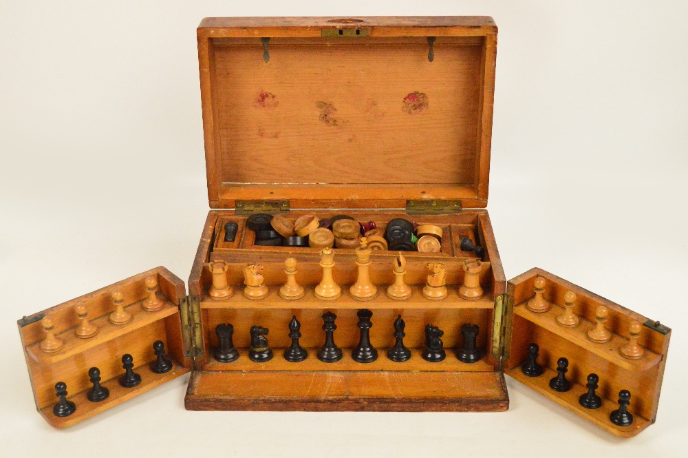 An oak cased games compendium comprising a wooden Staunton pattern chess set, height of king 6.