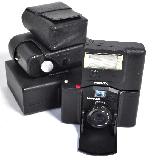 A Minox 35EL compact camera outfit to include camera dedicated flashgun cases and instructions.