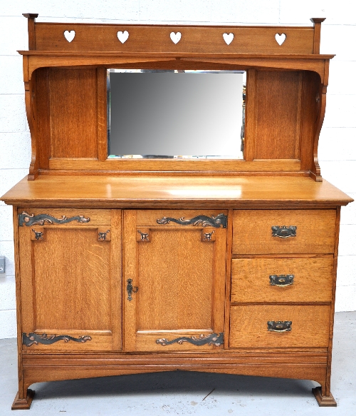 An early 20th century Arts and Crafts mirror back sideboard oftwo doors and three drawers down one