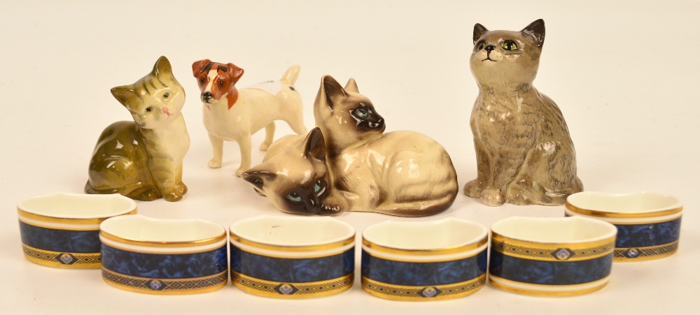 Four Beswick animals comprising two seated cats, a group of two Siamese kittens and terrier, also