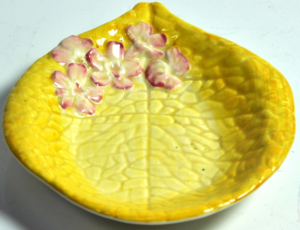 A small yellow Clarice Cliff cabbage pattern pin dish with pink flowers.