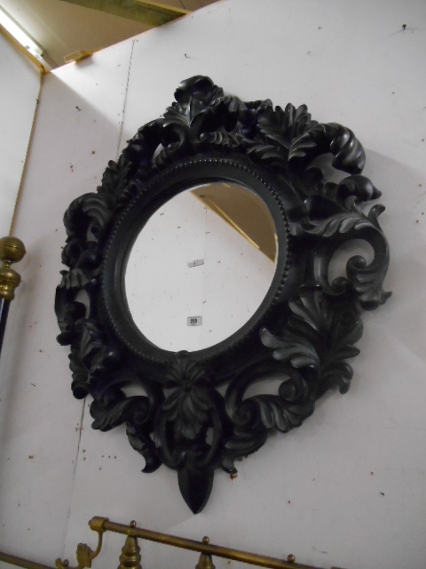 An Ornate Carved Effect Circular Bevelled Mirror, Black.