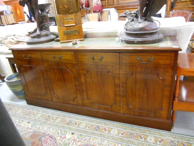 A Mahogany Sideboard, 20th Century with tooled green leather top above four cupboards. 68"" wide.