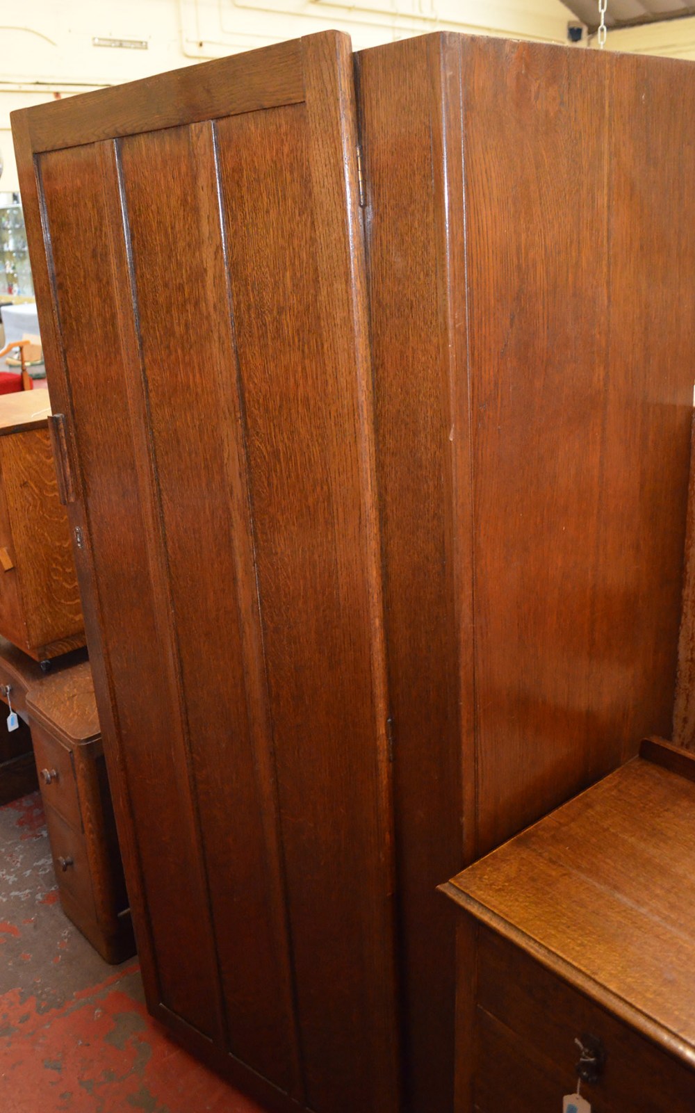 A four-piece oak bedroom suite, comprising a wardrobe, chest of three drawers, a mirror-backed