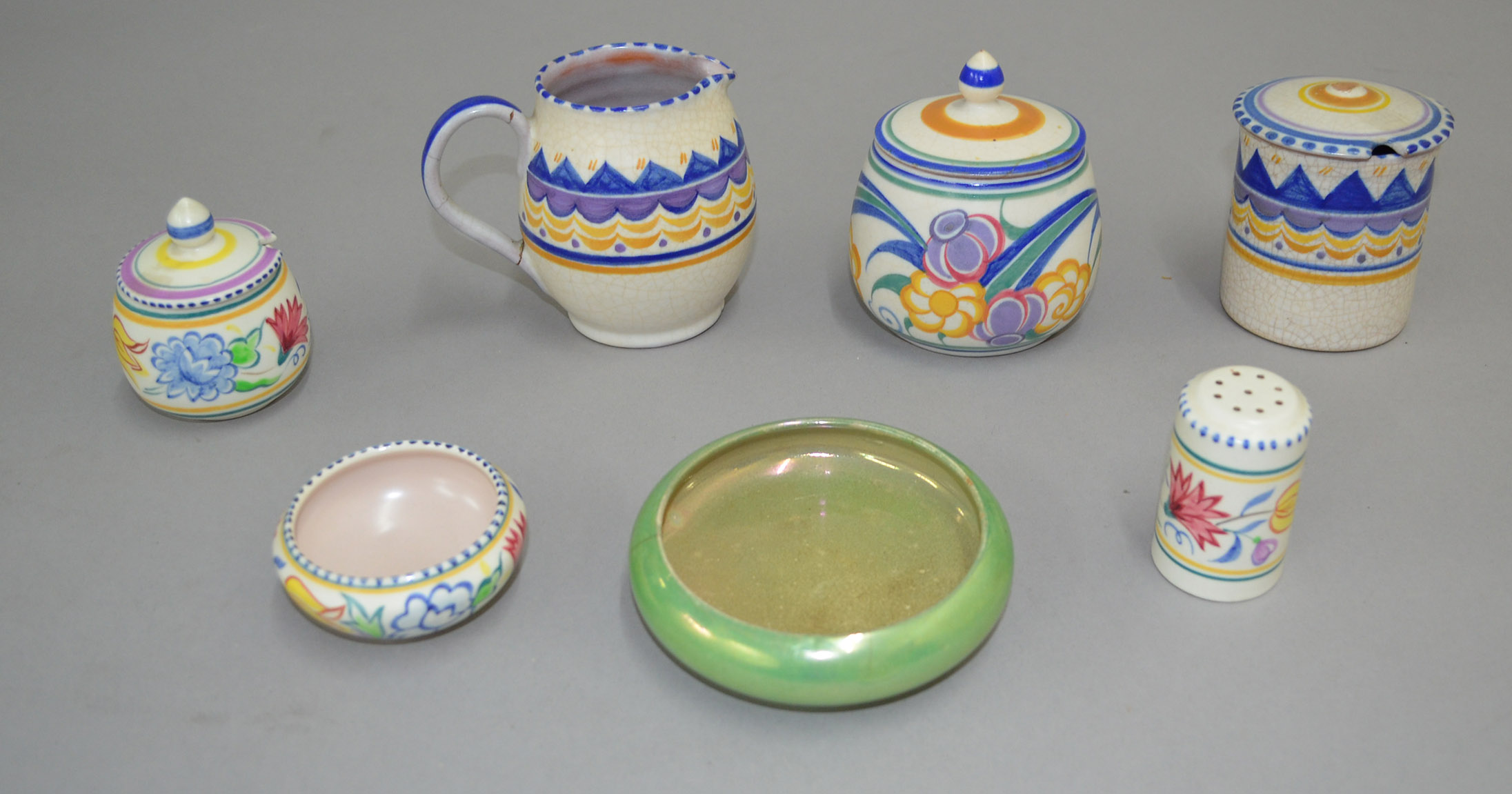 Six items of colourful Poole Pottery, together with an unusual green Moorcroft shallow dish.