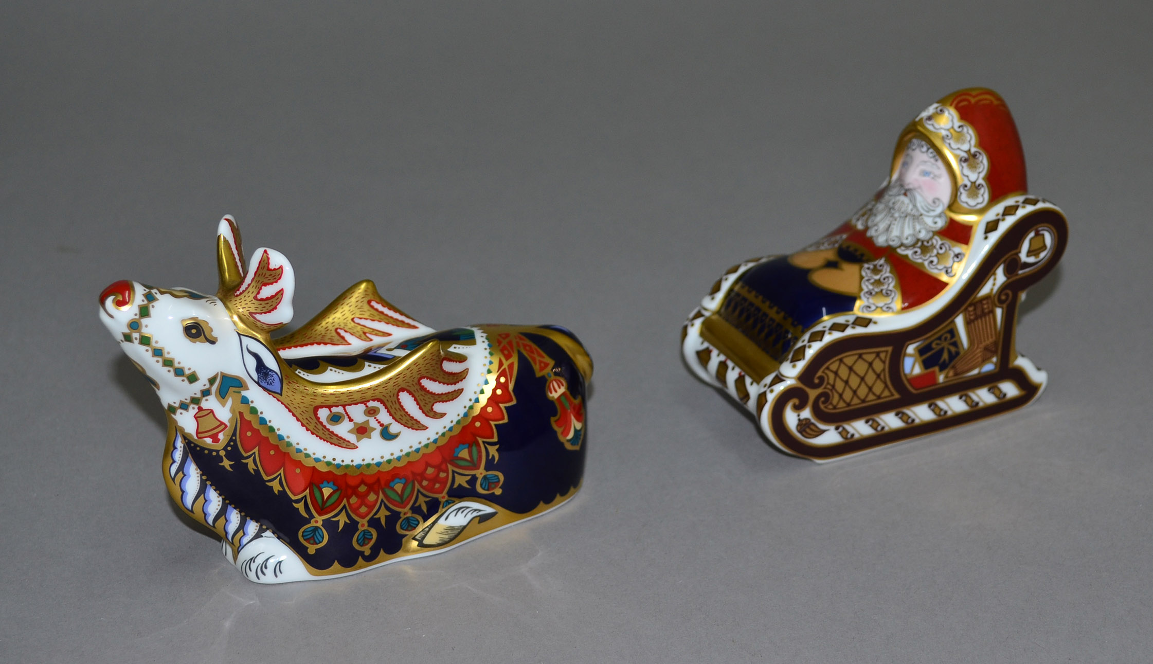 Royal Crown Derby `Santa & Sleigh` paperweight, together with `Reindeer` paperweight. Both boxed.