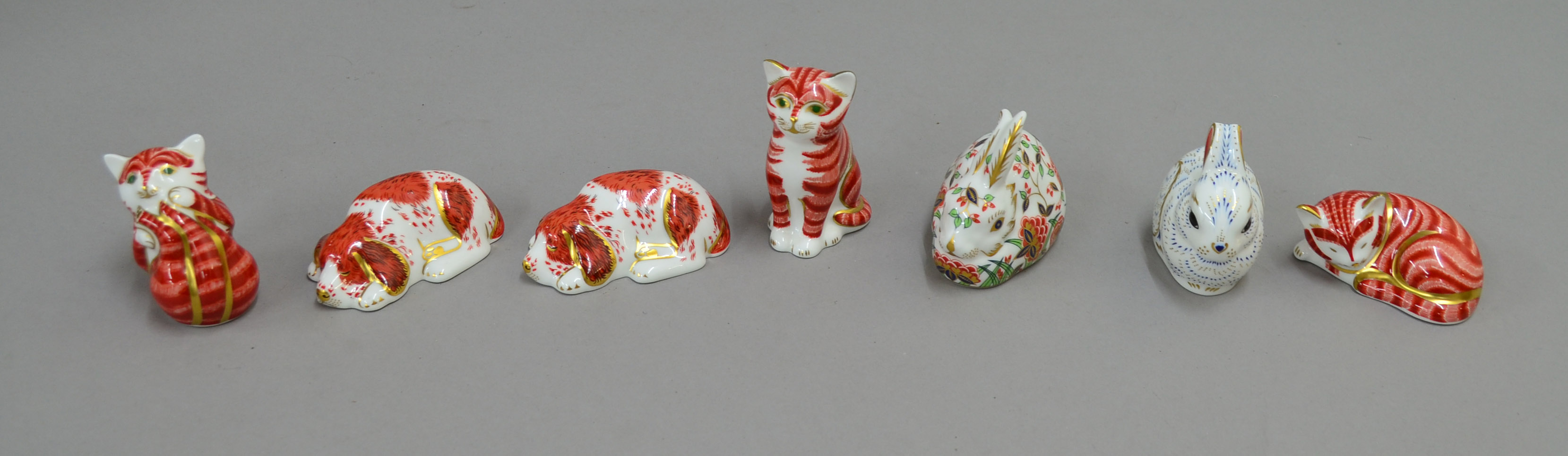 Seven Royal Crown Derby paperweights including 2 x `Puppy`, three striped cats, `Bunny` and `Meadow