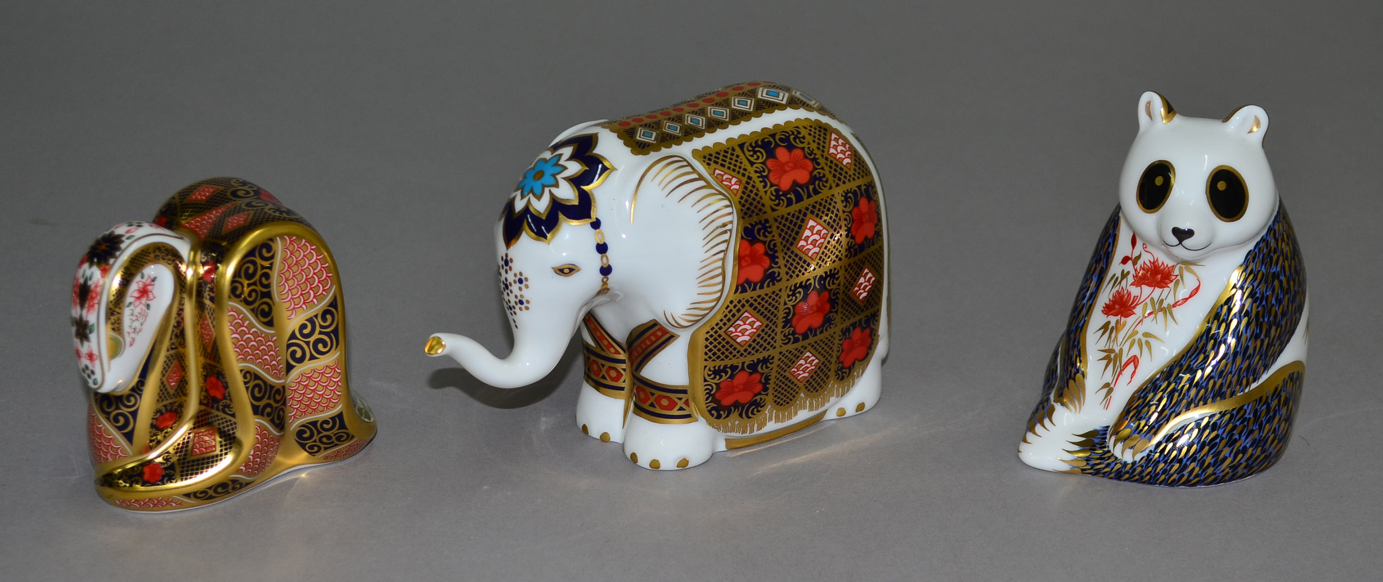 Three Royal Crown Derby paperweights in the form of an elephant, a snake and a panda. All boxed.