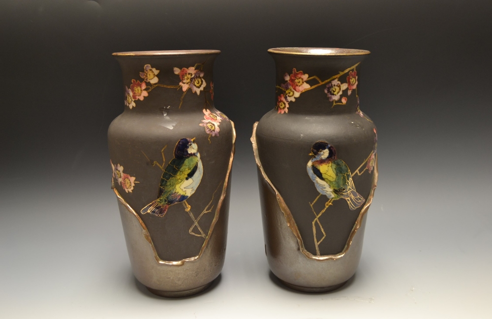 A pair of Bretby pottery vases, painted with birds perched on branches, lusterous black, brown