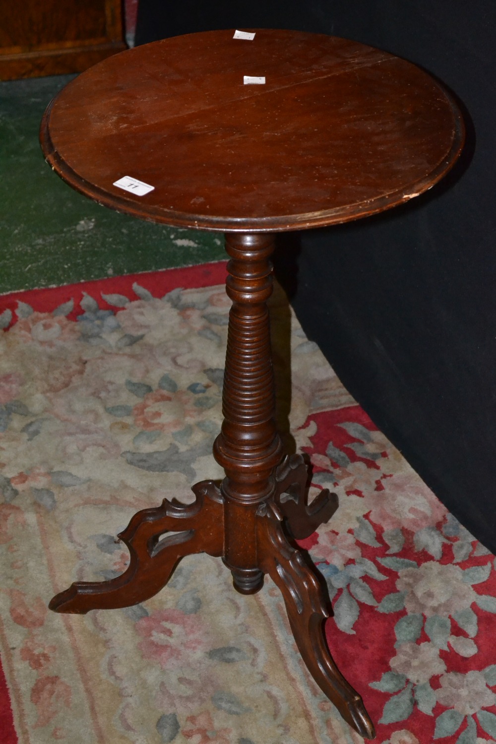 A Victorian tripod table, circular top, turned column, pierced and shaped legs.