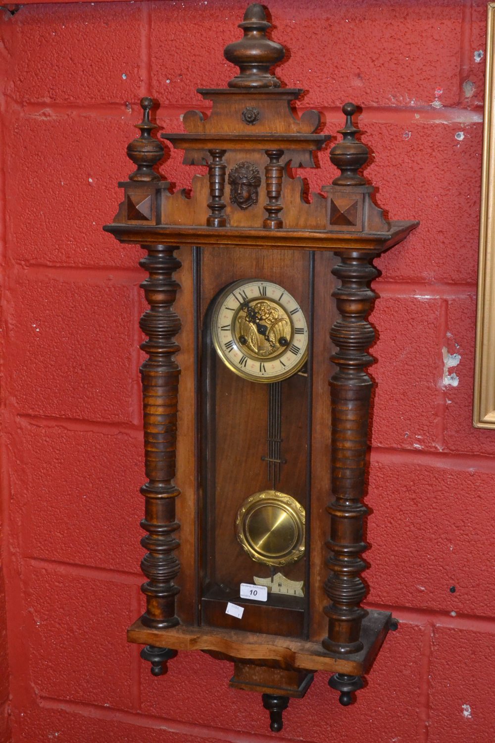 A mahogany Vienna wall clock, carved pediment, turned finials, with key and pendulum