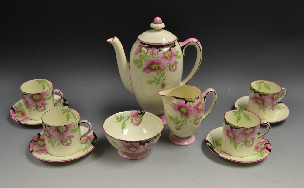 A Royal Doulton Rose pattern coffee pot, cream and sugar, four coffee cans and saucers