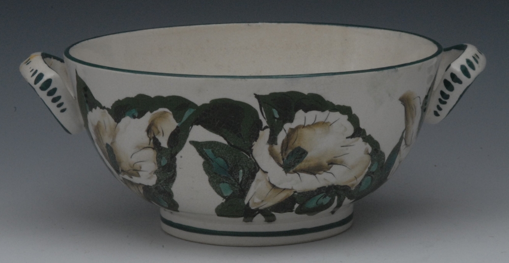 A Wemyss type two-handled bowl, painted with white trumpet flowers  and foliage, green line rim,