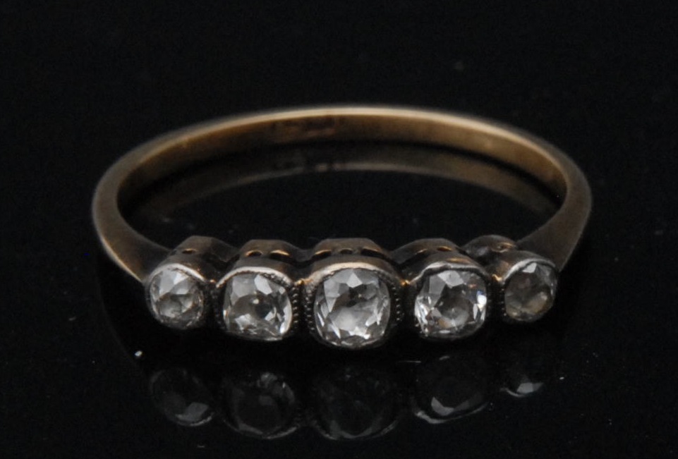A five stone diamond band ring, central brilliant cut diamond, flanked by two pairs of graduated