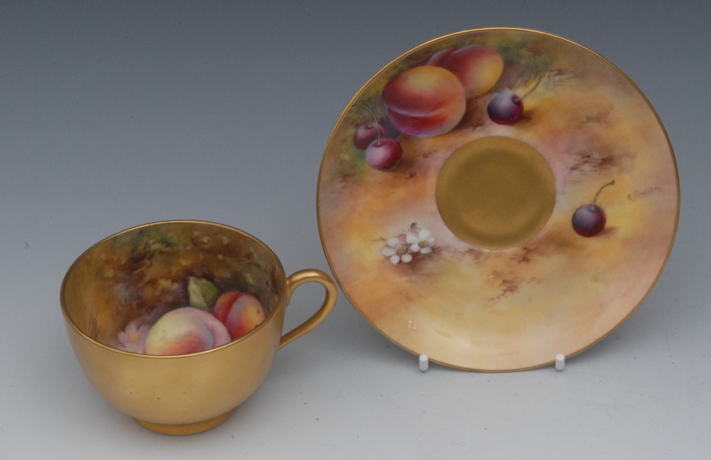 A Royal Worcester tea cup and saucer, painted by E Townsend, the saucer signed, with ripe fruit on a