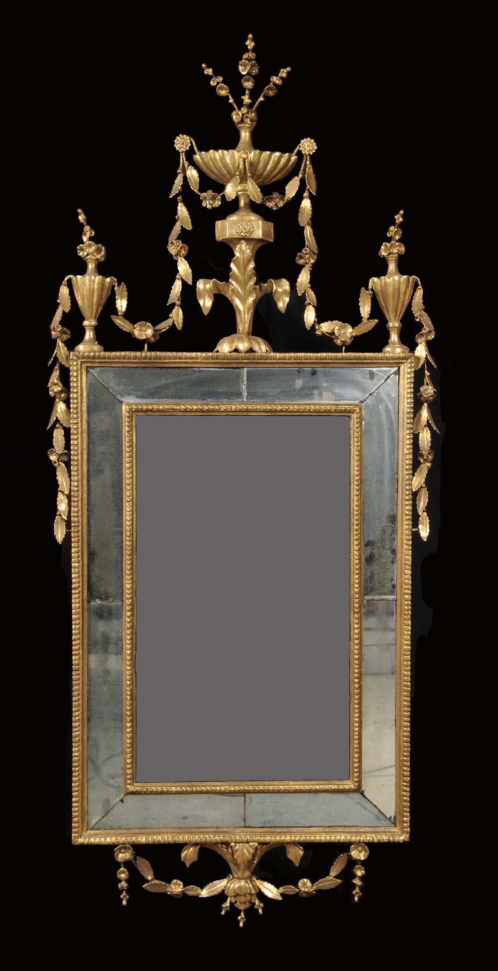 A George III giltwood rectangular looking glass, fluted urn and flowering leafy swag cresting and