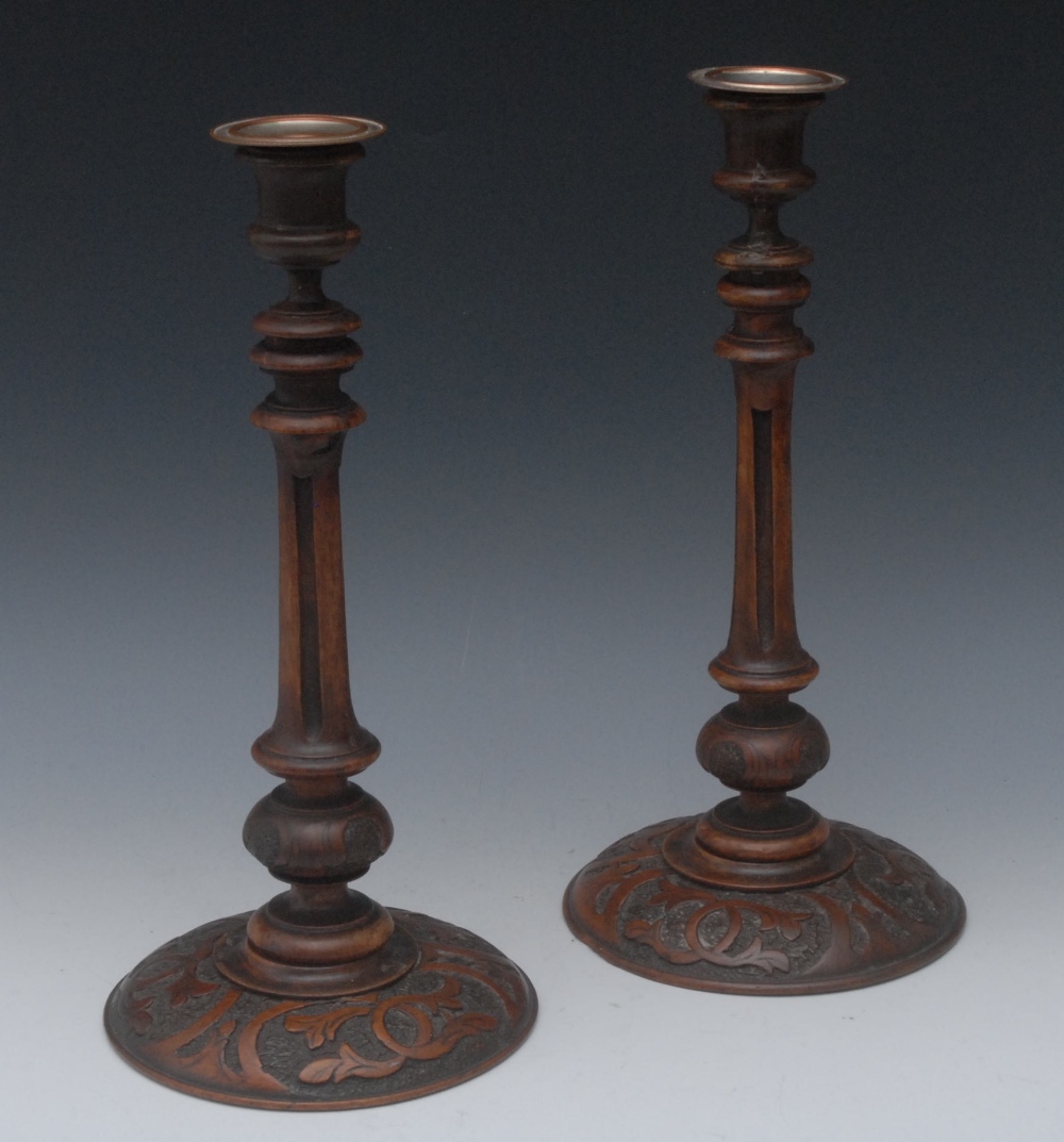 A pair of Victorian mahogany table candlesticks, urnular sconces, turned and fluted columns, domed