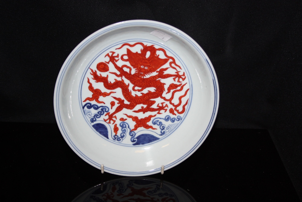 A Chinese dish, decorated in underglaze blue, boldly painted with red dragons, Kangxi marks but