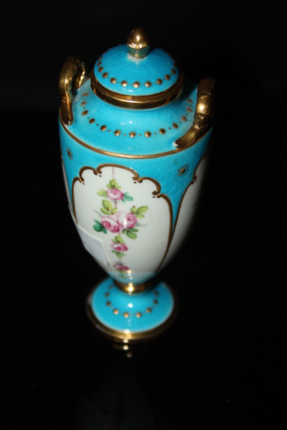 A Mintons diminutive vase and cover, decorated with panels of roses on a blue celeste ground, gilt