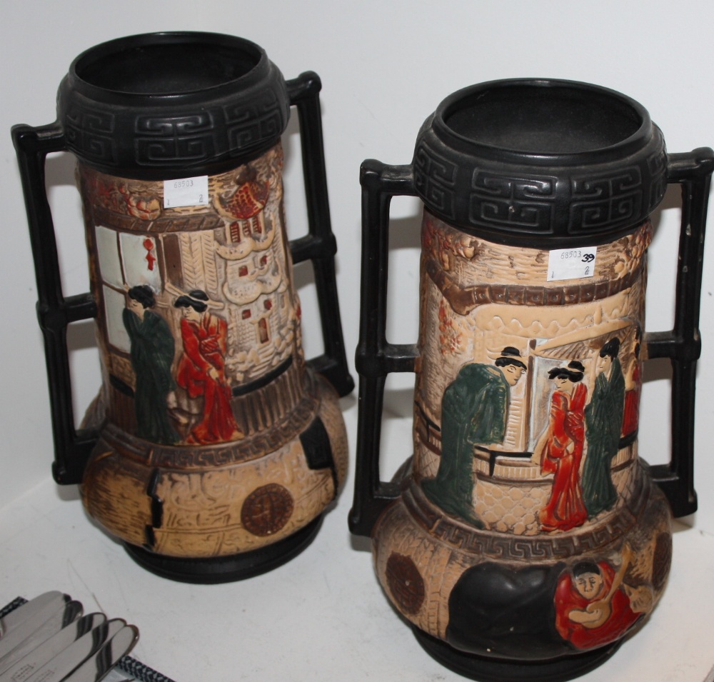 A pair of Embosa Ware two handled vases, in the Aesthetic Movement, decorated with stylized court