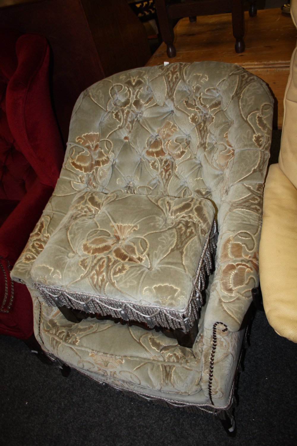 An early 20th century slipper back armchair, splay legs; an early 20th century footstool turned