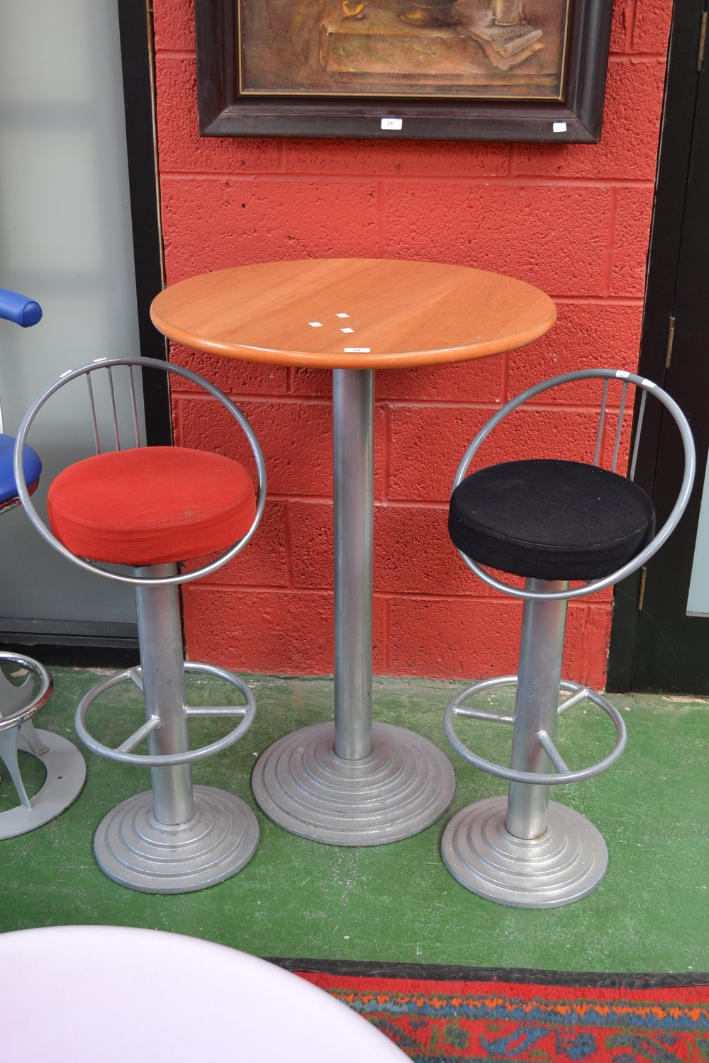 A beech effect cocktail table, circular top, steel column, stepped circular base, two conforming bar